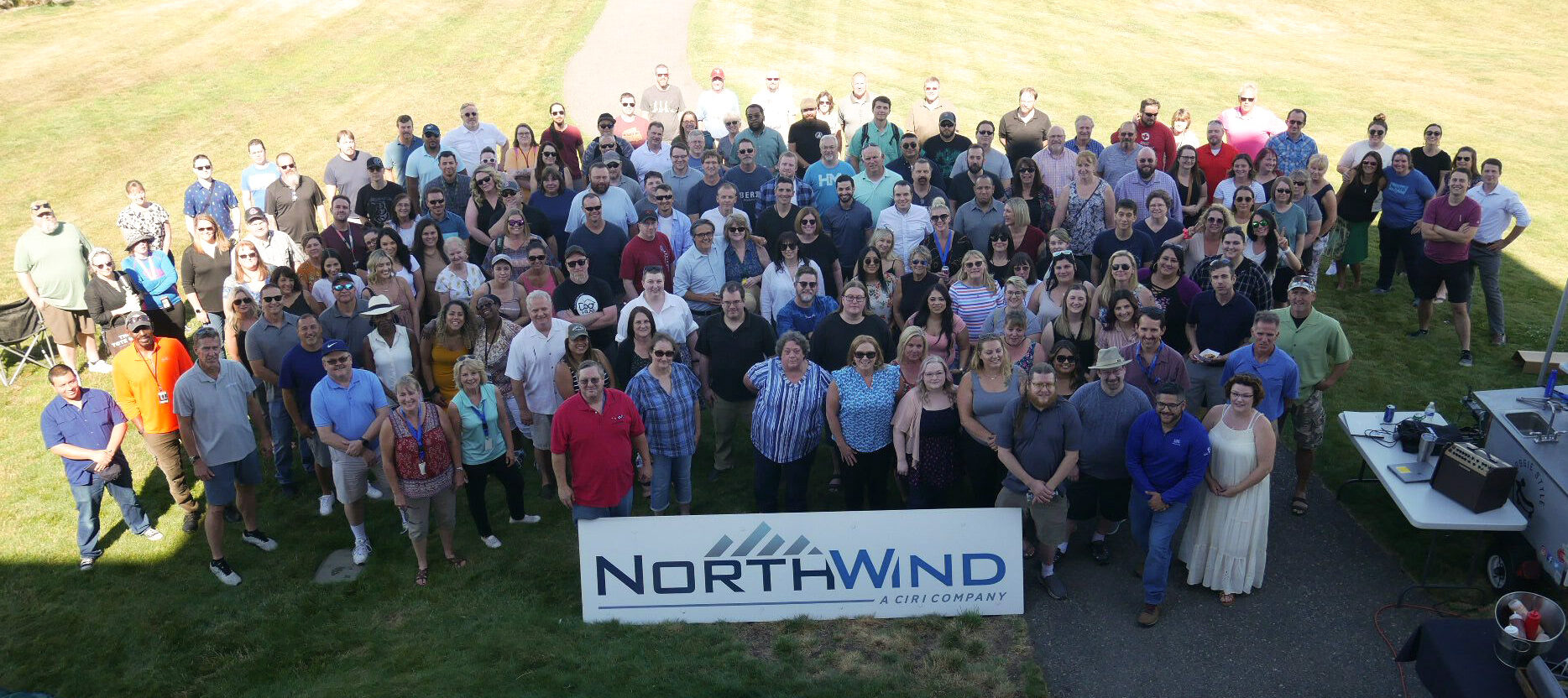 Aerial shot of employees in front of a North Wind sign