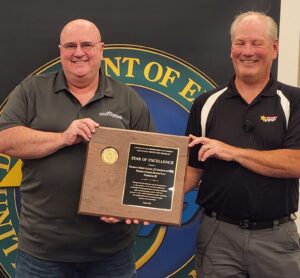 Photo of Mike Horton receiving the VPP Star of Excellence Award Plaque from Brad Davy from the DOE