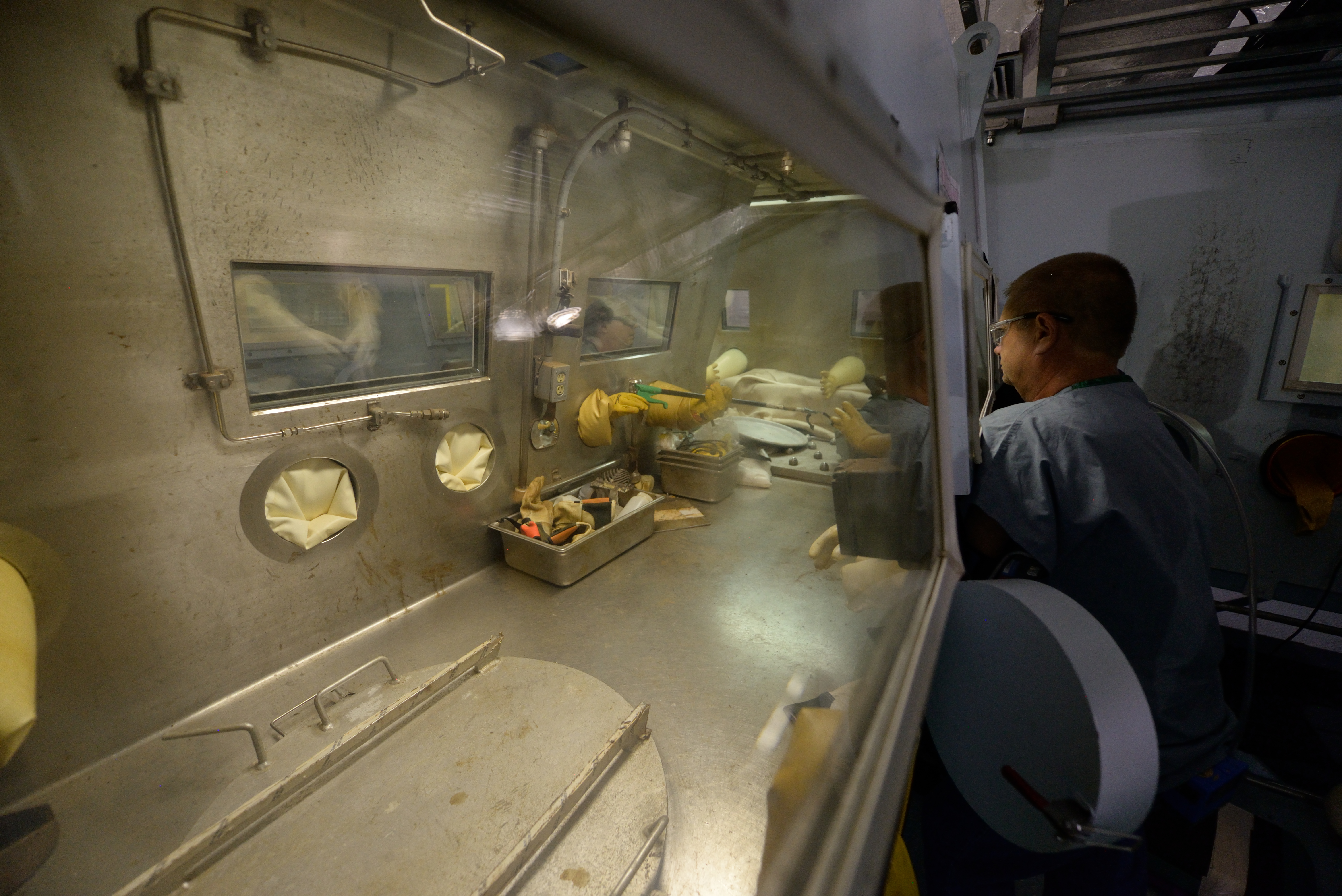 Photo of employee working with arms in a glovebox system