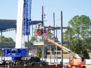 Photo of last piece of structural steel being put into place on building