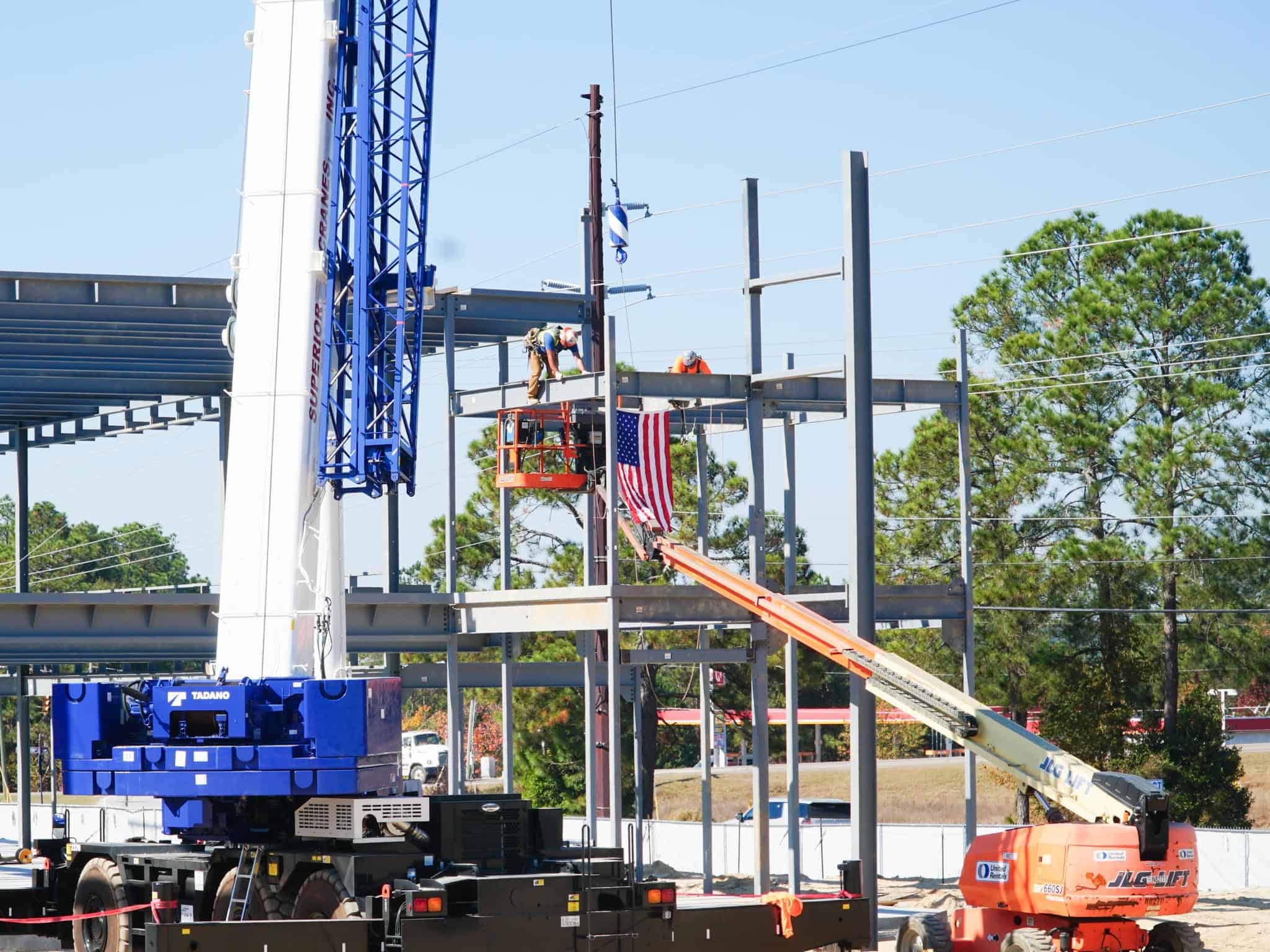 Photo of last piece of structural steel being put into place on building