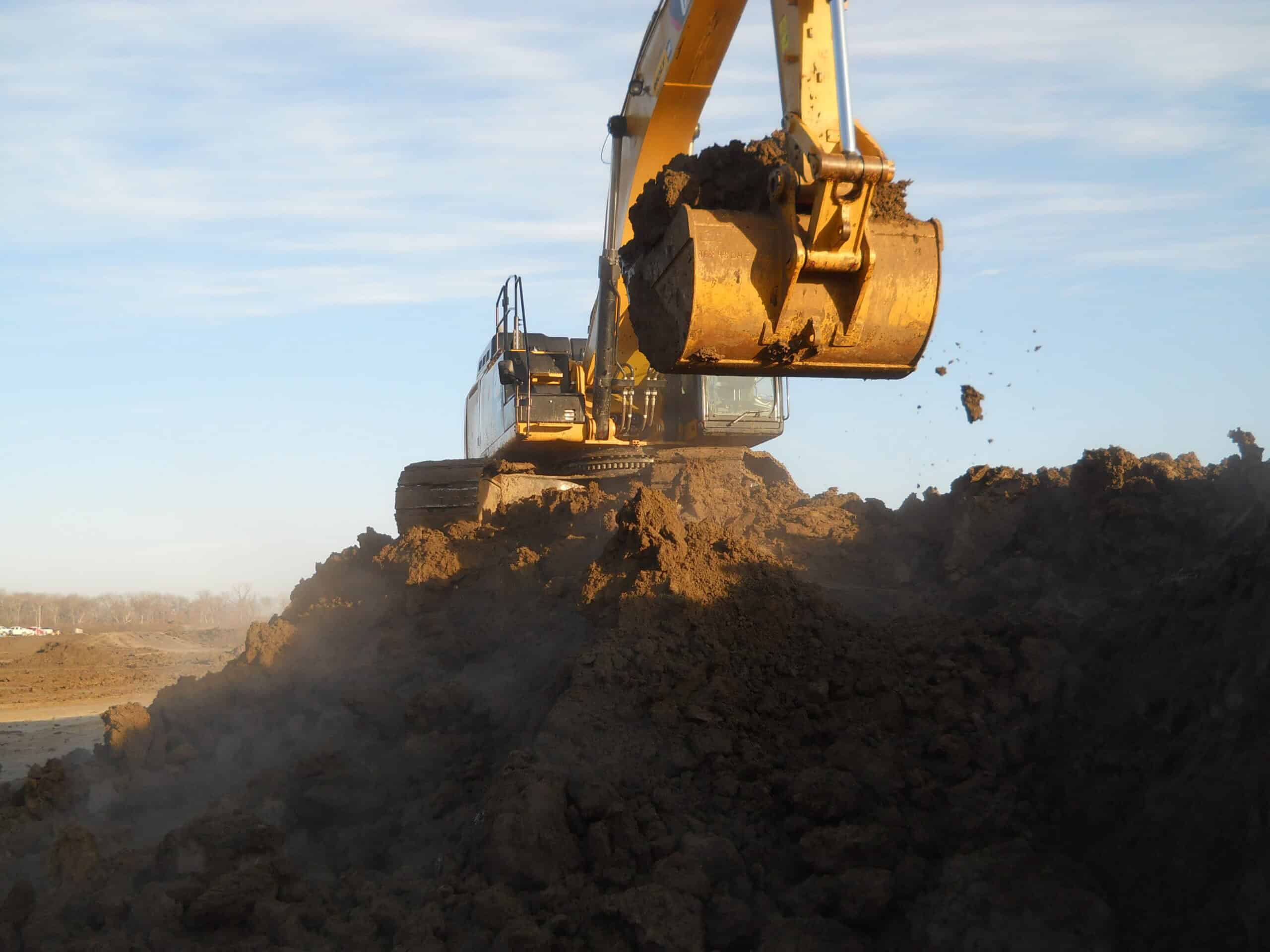 Photo of excavator in Kaufman, Texas working on levee in dirt pile