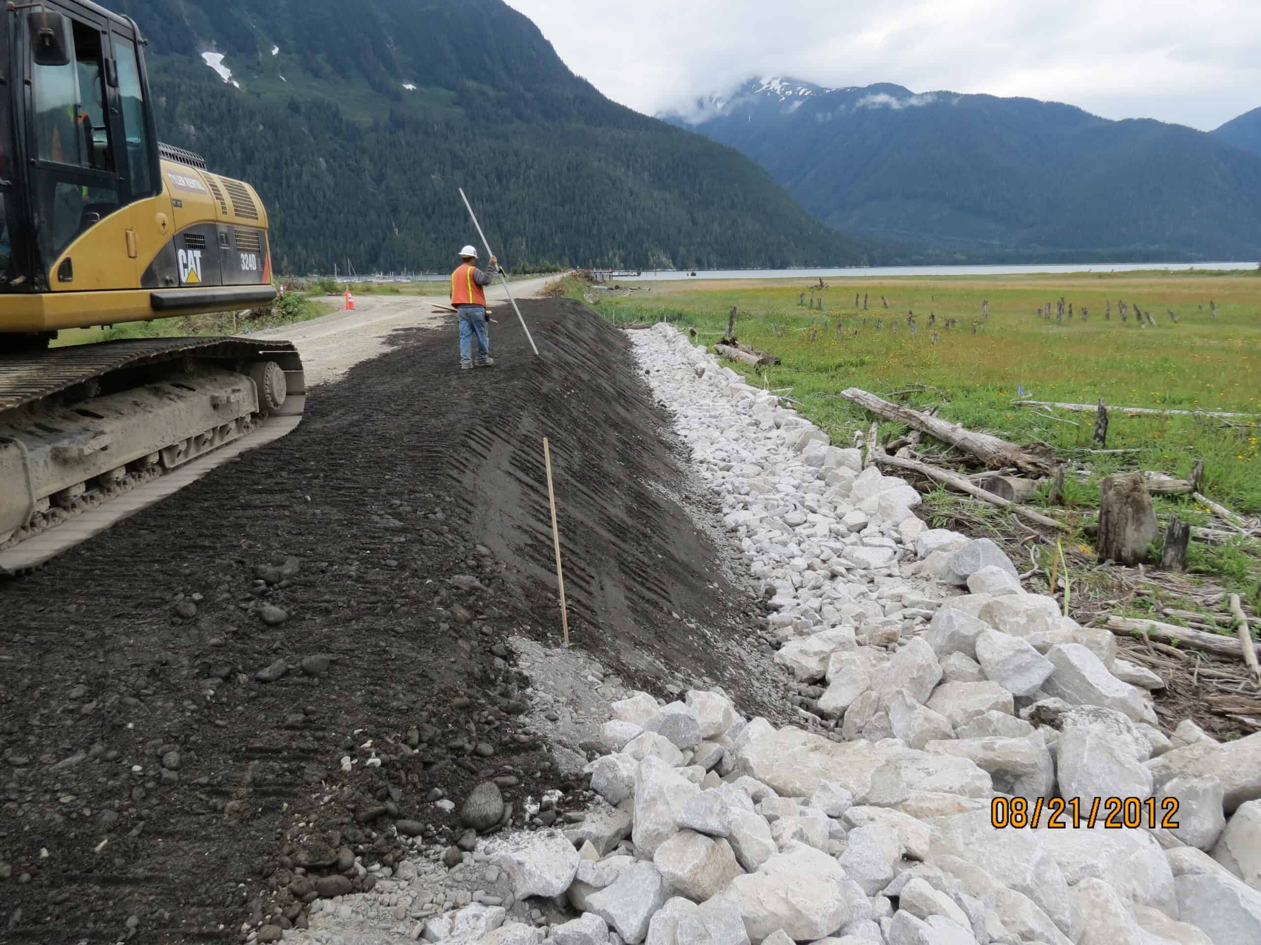Photo of construction equipment in the foreground on the Hyder Causeway in Alaska
